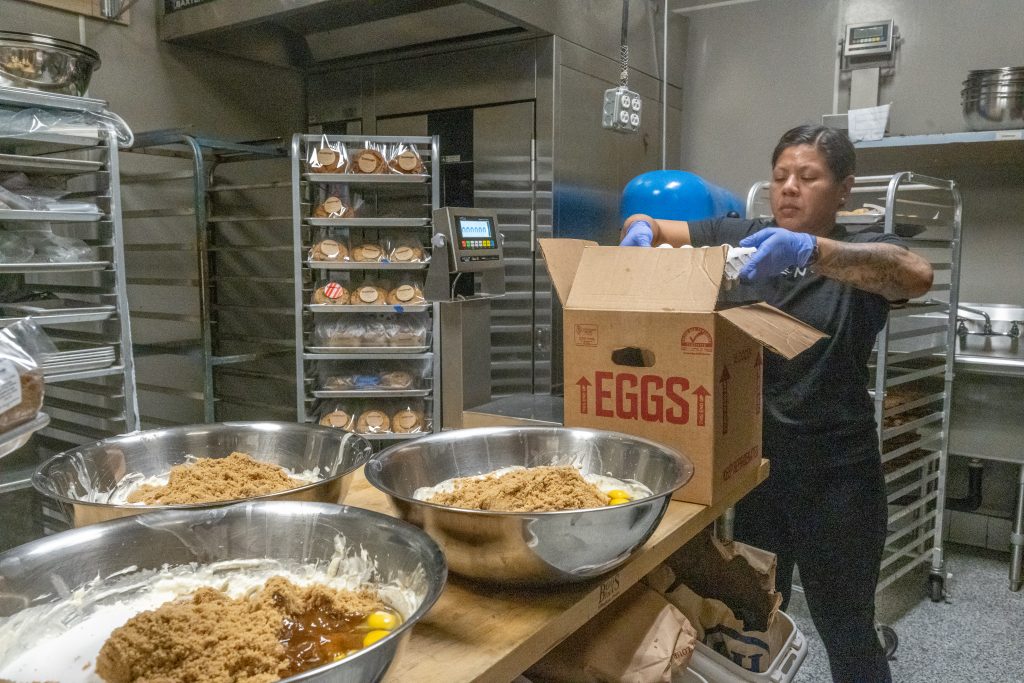 Baker working in a professional kitchen with ingredient bowls and eggs