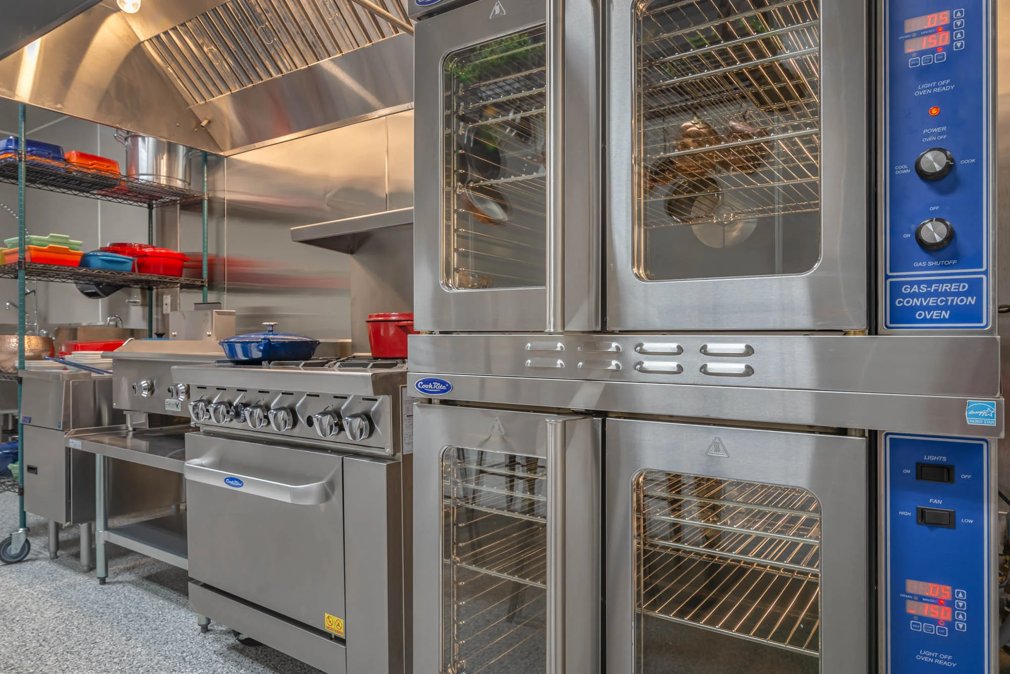Professional commercial kitchen featuring a large stainless steel convection oven.