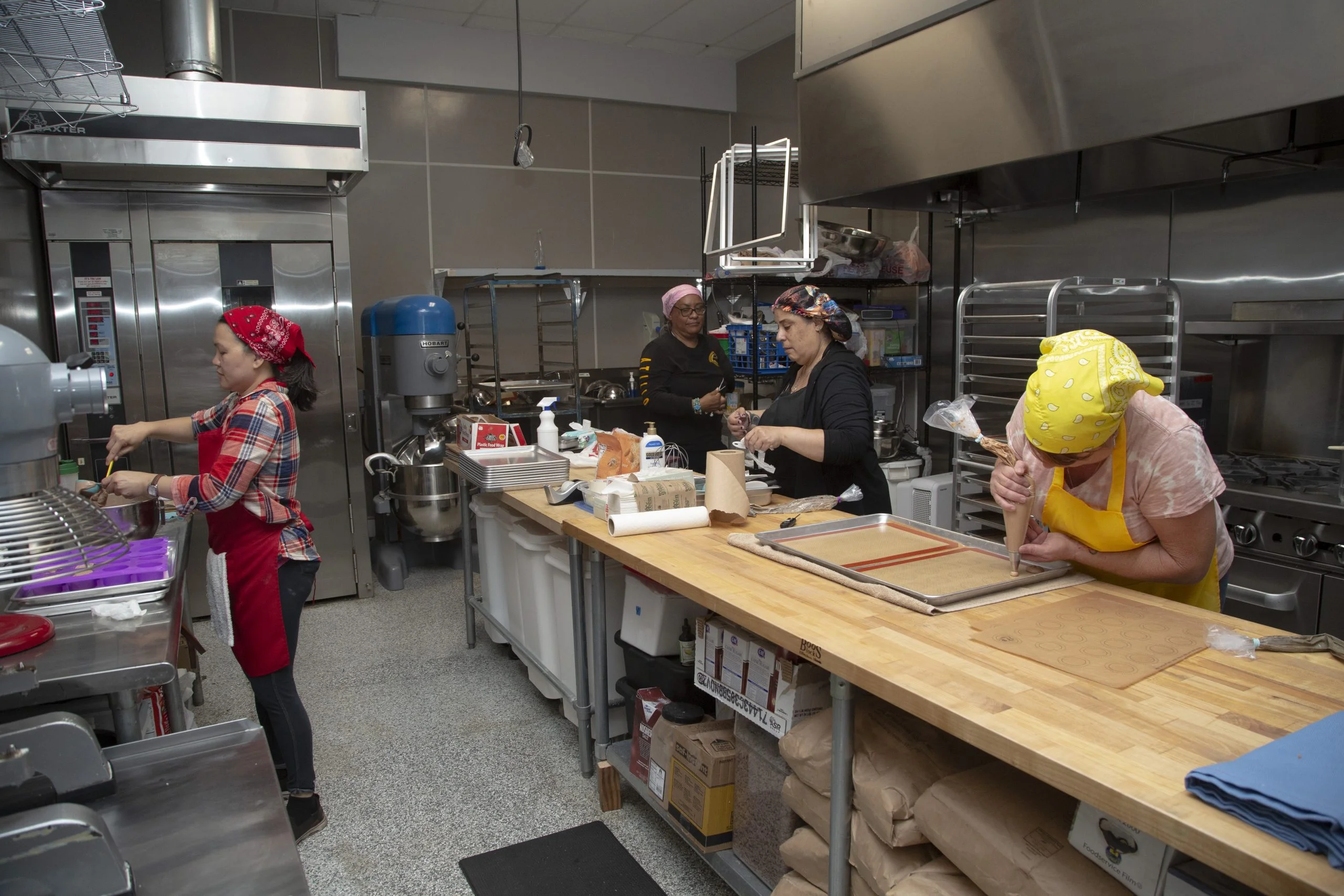Team of bakers working in a professional commercial kitchen on food preparation.